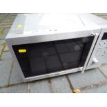 A DeLonghi microwave with operating manual