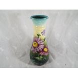 A Doulton baluster vase decorated with floral depictions, impressed mark L9007 to the base, 31cm