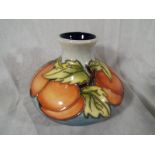 A Moorcroft Pottery bulbous vase decorated with fruit and foliage, impressed factory marks to the