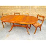 A contemporary mahogany oval topped dining table with extension and four dining chairs
