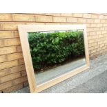 A modern rectangular bevel edged wall mirror, in wooden frame,