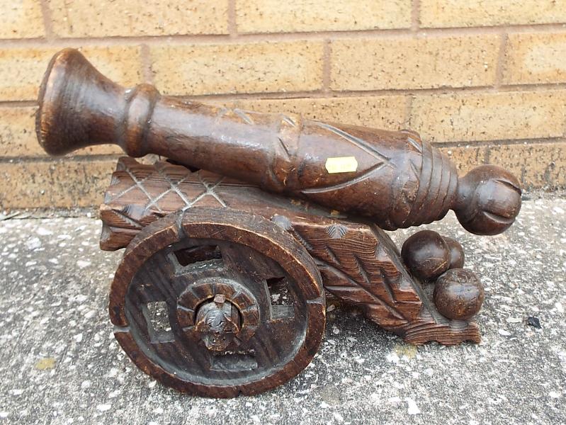 An ornamental carved wooden canon 28 cm (h) x 40 cm (l)