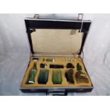 A salesman's attached case containing samples of glassware to include bottles and drinking glasses