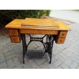 An early 20th century oak cased treadle sewing machine by Singer
