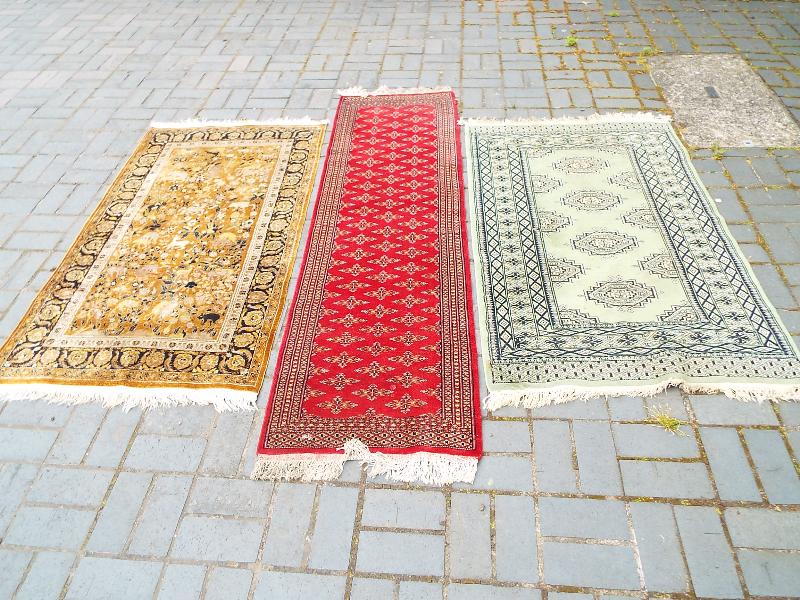 A collection of three rugs, green rug measures 95cm x 142cm, red runner measures 62cm x 205cm,