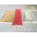 A collection of three rugs, green rug measures 95cm x 142cm, red runner measures 62cm x 205cm,