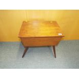 A sewing cabinet with hinged lid and splayed legs,