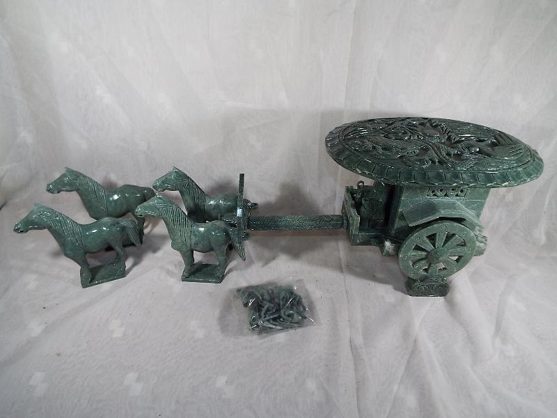 An oriental carved jadeite horse drawn carriage with relief decoration to the roof depicting a