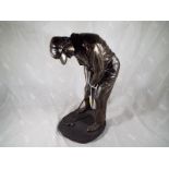 A bronzed figurine depicting a golfer, signed to the base,