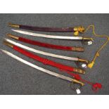 Five Eastern curved bladed swords in scabbards,