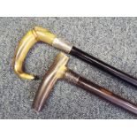 Two gentleman's walking sticks with horn handles, each with silver hallmarked collars,