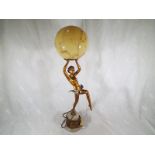 A table lamp in the form of a female on a marble plinth with smoked glass ball shade,