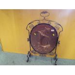 A wrought iron and copper fireguard depicting a sailing ship at sea,