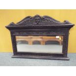 An over mantel bevelled edged mirror mounted in a highly carved frame 59cm (h) x 87 (w) x 6cm (d)