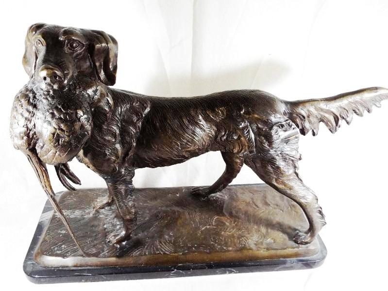 A large bronze sculpture depicting a gundog carrying a pheasant mounted on an Italian marble base,