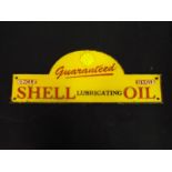 A cast iron sign marked Guaranteed Shell Lubricating Oil,