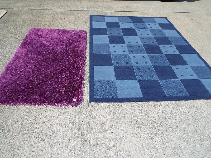 Two rugs, one with blue check, approx size 170cm x 230cm and another purple,