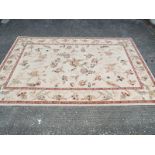 A floral pattern rug predominantly cream and beige,