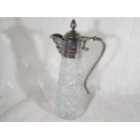 A glass claret jug with silver plated rim, handle and mask spout, engraved The Harry Tittle Trophy,