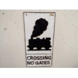 A cast iron sign with depiction of a locomotive, marked Crossing No Gates,