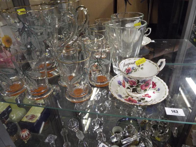 A unusual art glass drinking set to include jug and six drinking glasses decorated with a floral