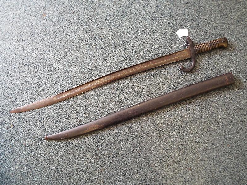 A 19th century French curved sword bayonet with brass handle and metal scabbard,