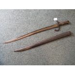 A 19th century French curved sword bayonet with brass handle and metal scabbard,