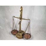 A brass weighing balance with graduated brass weights