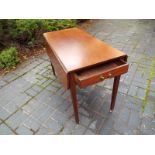 A mahogany Sutherland table, on tapered reeded supports terminating in castors,