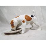 A Royal Doulton figurine depicting a dog eating from a plate HN 1158