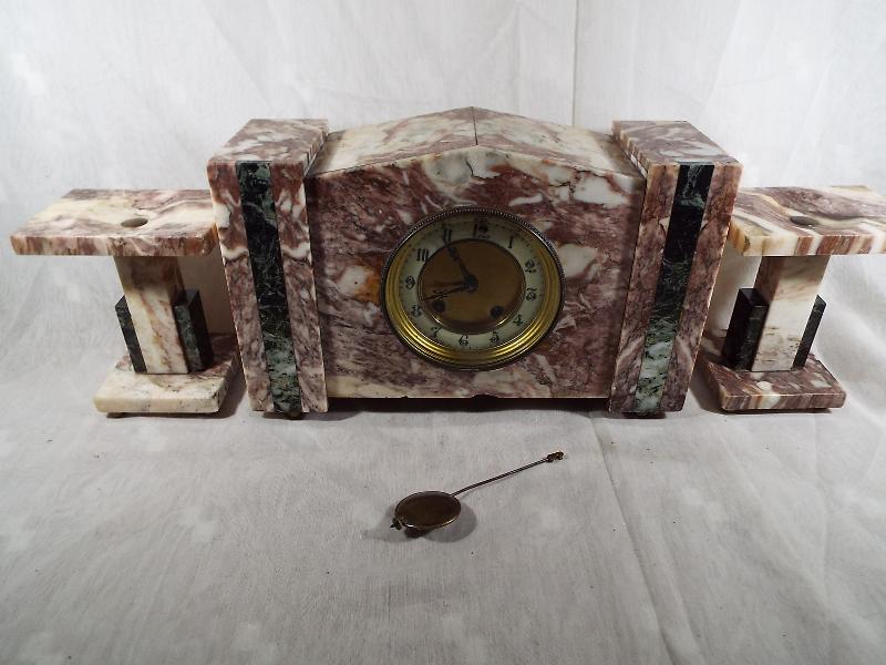 An Art Deco styled clock set in pink and white veined marble and green marble accents,
