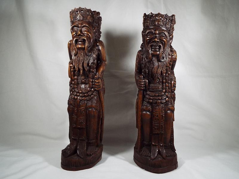A pair of Oriental figural carvings depicting Chinese characters, 35.