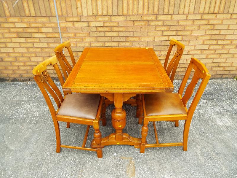 An Oak extending table 74cm x 99cm x 84cm extending to 166cm with four dining chairs (qty)