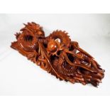 A hard wood carving depicting the dragon chasing the flaming pearl,