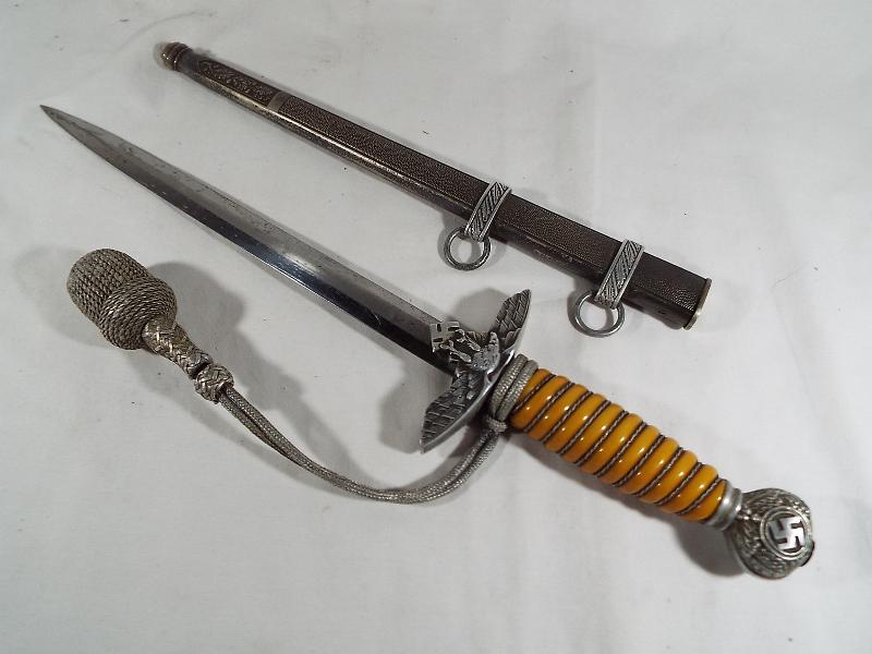 A Third Reich German Luftwaffe dagger with woven white metal wire bound orange celluloid grip,