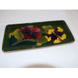 Moorcroft Pottery - A rectangular pen tray decorated with hibiscus on a green ground with paper