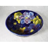 A Moorcroft Pottery pedestal bowl decorated with clematis on a blue ground, signed to the base,