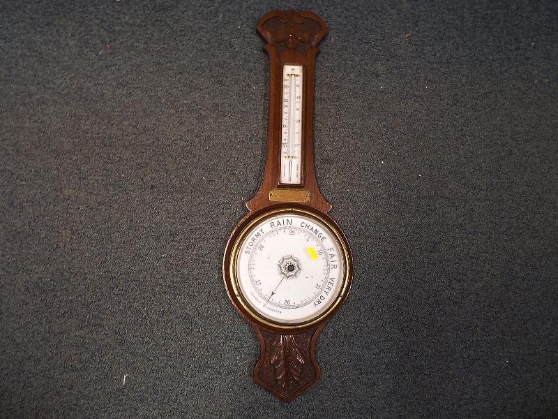 An early 20th century oak cased banjo-style aneroid wall barometer,