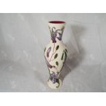 A Moorcroft Pottery slender vase decorated with orchids on a cream ground, 20.