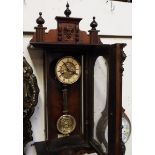 A spring-driven wall mounted Vienna style wall clock, the walnut case flanked by turned columns,