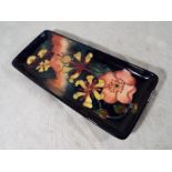 A Moorcroft Pottery rectangular tray decorated in a floral design,