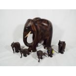 Six carved hard wood figurines depicting elephants,