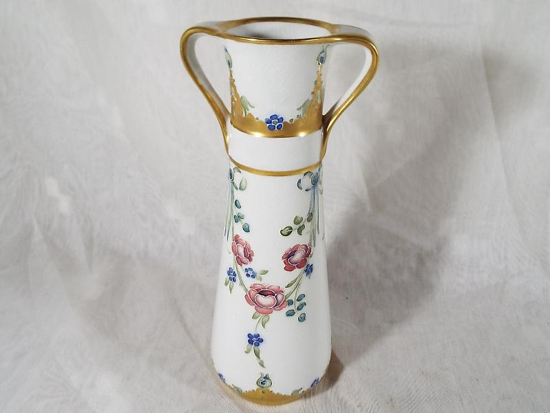 A MacIntyre / Moorcroft Pottery twin-handled tapered vase decorated with roses and garlands on an