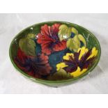 A Moorcroft Pottery pedestal bowl decorated with hibiscus on a green ground,