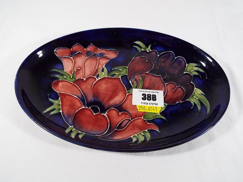 Moorcroft Pottery - A Moorcroft Pottery oval tray decorated with anemone on a cobalt blue ground