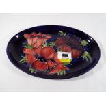 Moorcroft Pottery - A Moorcroft Pottery oval tray decorated with anemone on a cobalt blue ground