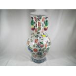 A large Chinese Famille Rose vase with handles depicting children decorated with fruit and