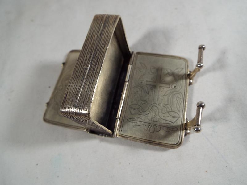 A silver vesta in the form of a miniature book with twin-internal compartments .800 - Image 4 of 5