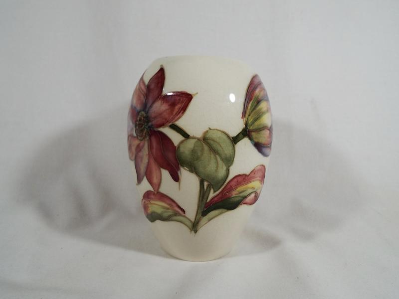 A Moorcroft pottery oviform vase with a floral pattern on a cream ground 11.