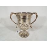 An Edwardian silver hallmarked twin handled trophy with fluted decoration, London assay 1904,